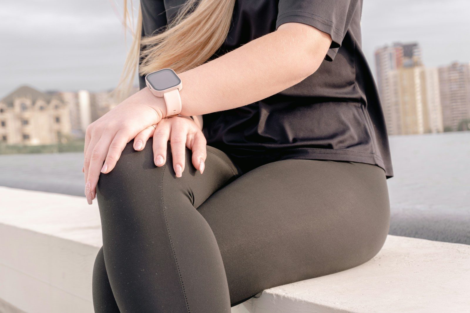 Woman in athletic wear sitting outdoors near water